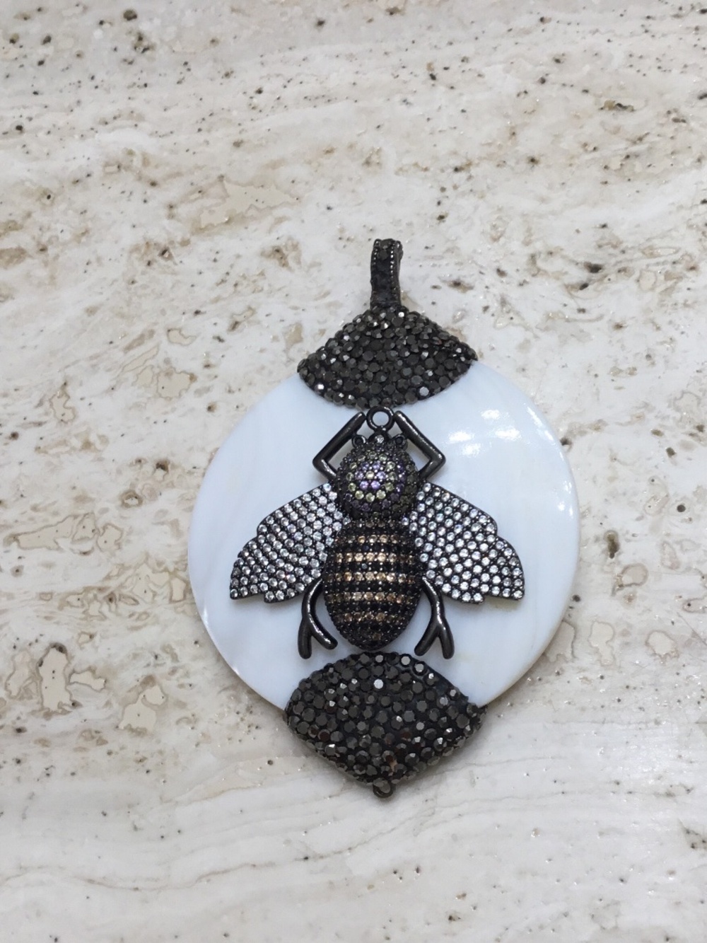 Bee‎ Pendant Gunmetal Tone Covered With Bling Sitting on White Pearlized Stone